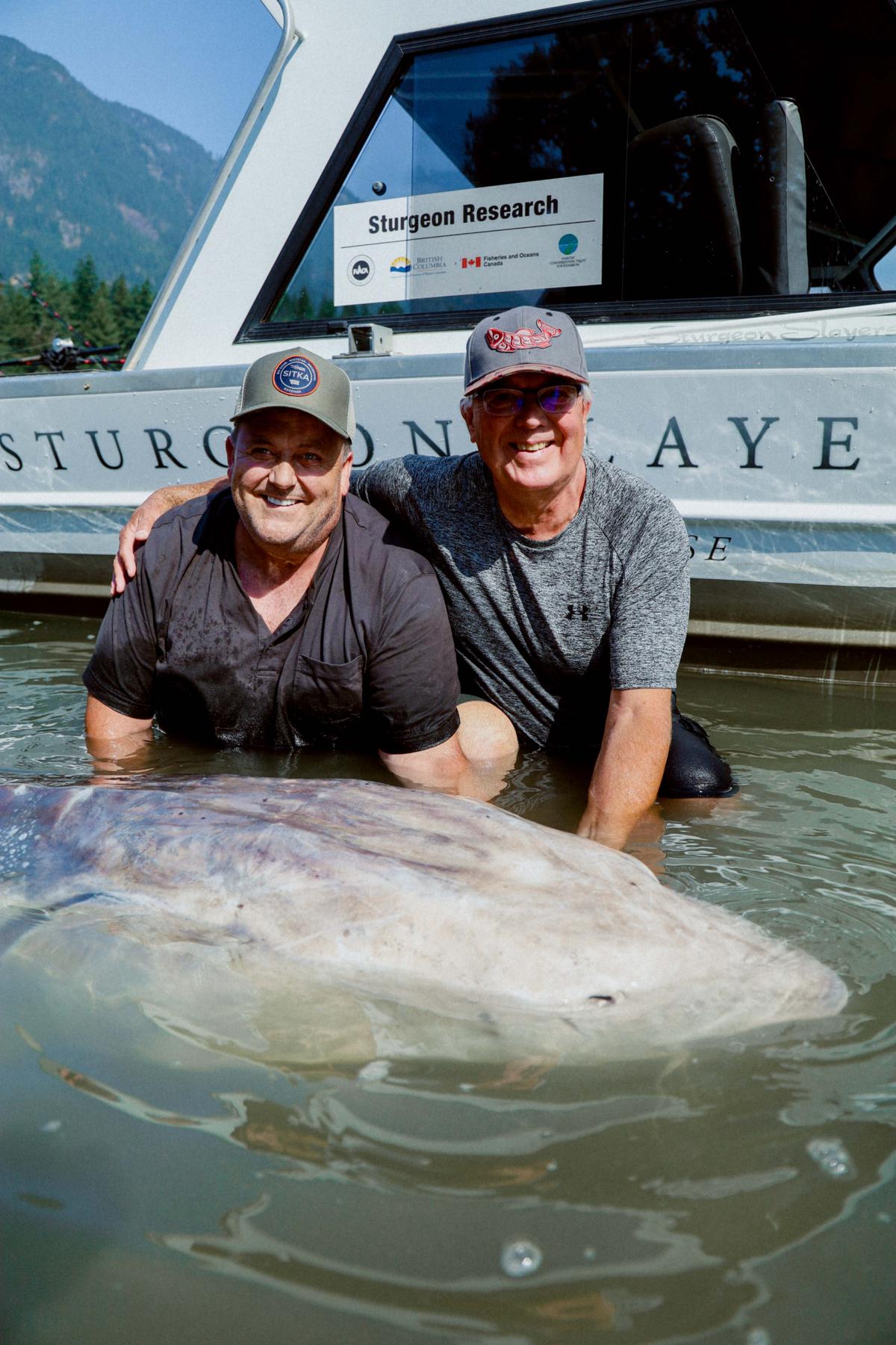 Longtime Sturgeon Slayers guests Bryant Bowtell (L) and brother Barry pose with the sturgeon. (Courtesy of <a href="http://www.sturgeonslayers.com/">Sturgeon Slayers</a>)