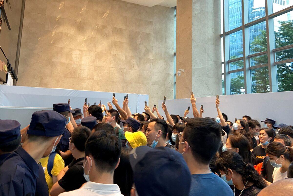 People gather to demand repayment of loans and financial products at Evergrande headquarters, in Shenzhen, Guangdong Province, China, on Sept. 13, 2021. (David Kirton/Reuters)