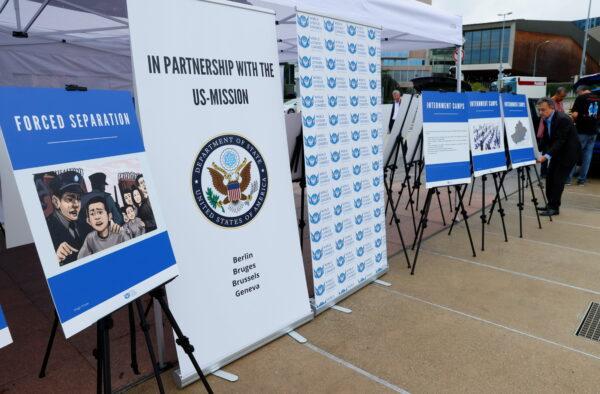 Dolkun Isa, President of the World Uyghur Congress, sets up the display at a U.S.-backed Uyghur photo exhibit of dozens of people who are missing or alleged to be held in Chinese-run camps in Xinjiang, in front of the United Nations in Geneva, Switzerland, on Sept. 16, 2021. (Denis Balibouse/Reuters)