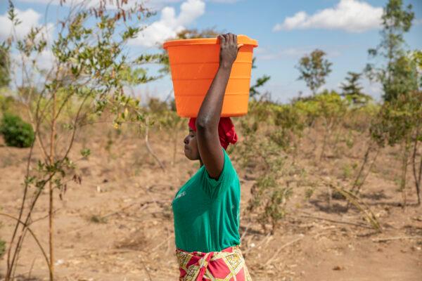 A woman carries water in Lupapa Village, Malawi, on July 6, 2021. (John Fredricks/The Epoch Times)