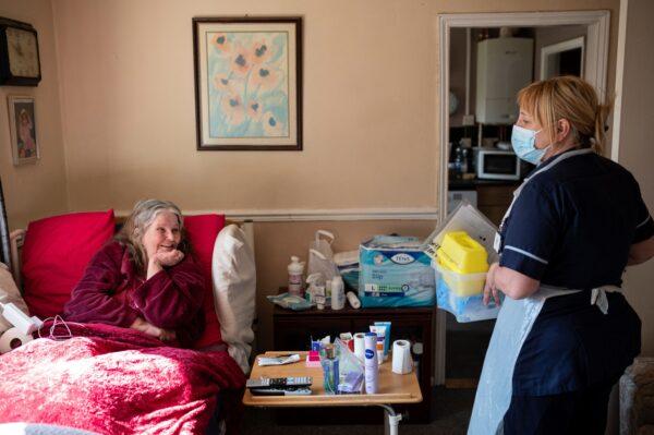 Team leader for housebound vaccinations, Julie Fletcher, with housebound patient Gillian Marriott at her home in Hasland, near Chesterfield, central England on April 14, 2021. (Oli Scarff/AFP via Getty Images)