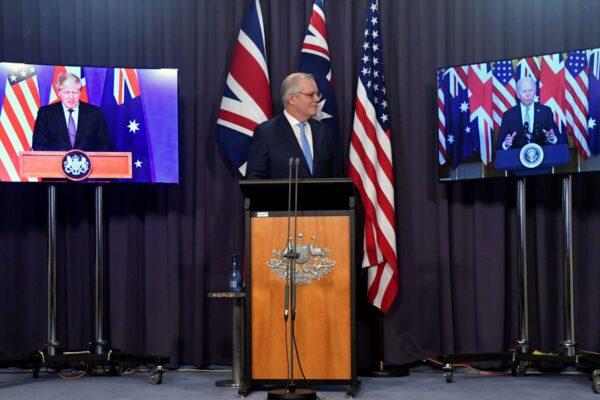 Australia's Prime Minister Scott Morrison (C) appears on stage with video links to Britain's Prime Minister Boris Johnson (L) and U.S. President Joe Biden (R) at a joint press conference at Parliament House in Canberra on Thursday, Sept. 16, 2021. (Mick Tsikas/AAP Image via AP)