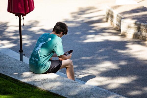 A student sits in the shade at Chapman University in Orange, Calif., on Oct. 14, 2020. (John Fredricks/The Epoch Times)
