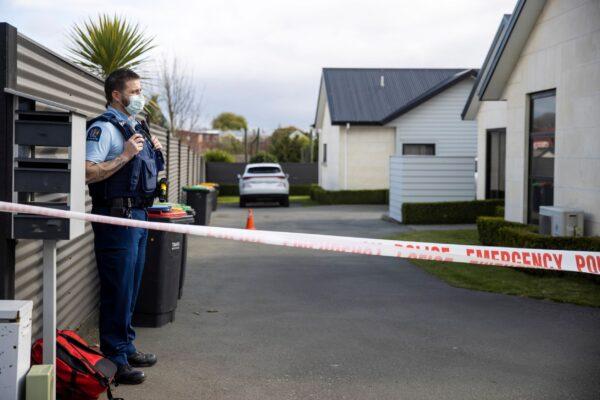 A police officer stands in the driveway of a house where three children were found dead in the South Island town of Timaru in New Zealand on Sept. 17, 2021. (George Heard/New Zealand Herald via AP)