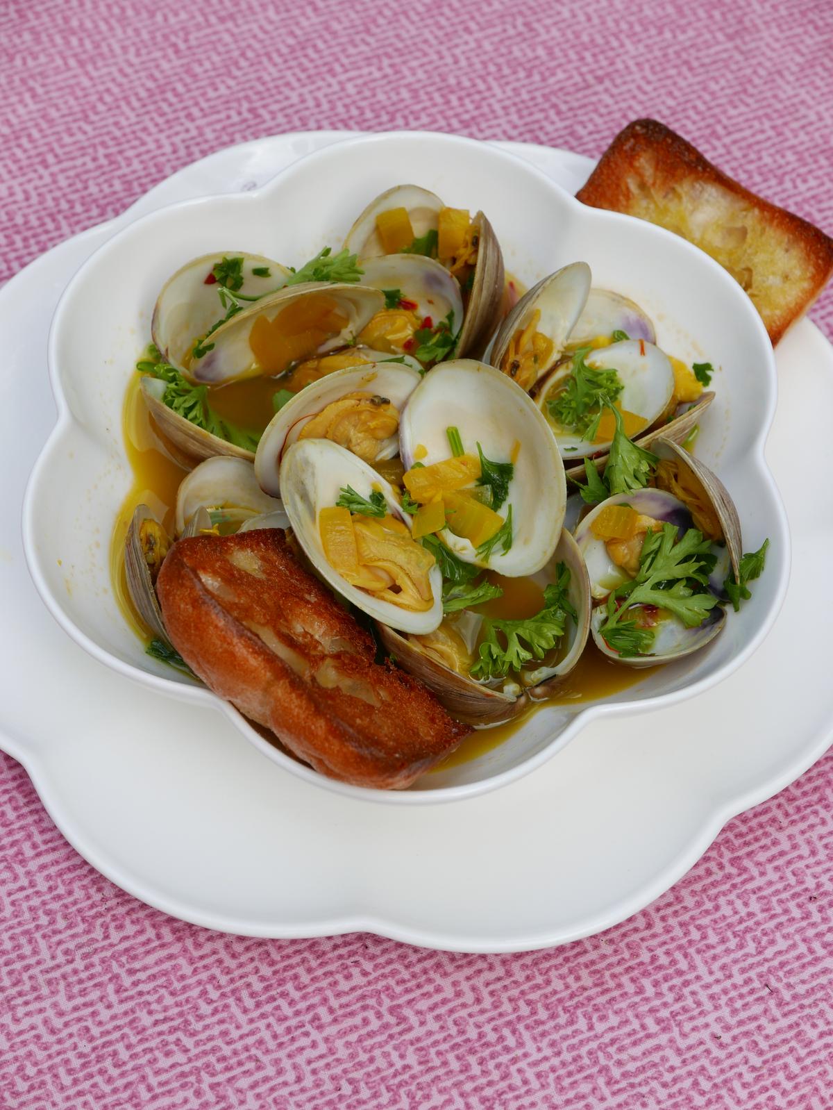 Serve these clams with plenty of garlic bread for dipping in the briny, saffron-infused sauce. (Victoria de la Maza)