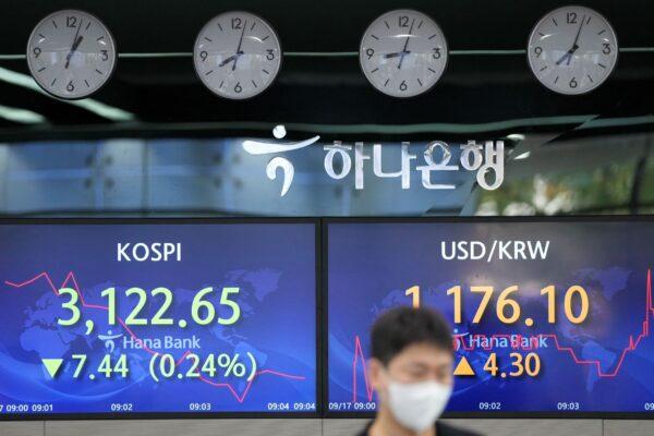 A currency trader walks by the screens showing the Korea Composite Stock Price Index (KOSPI), (L), and the foreign exchange rate between U.S. dollar and South Korean won at a foreign exchange dealing room in Seoul, South Korea on Sept. 17, 2021. (Lee Jin-man/AP Photo)