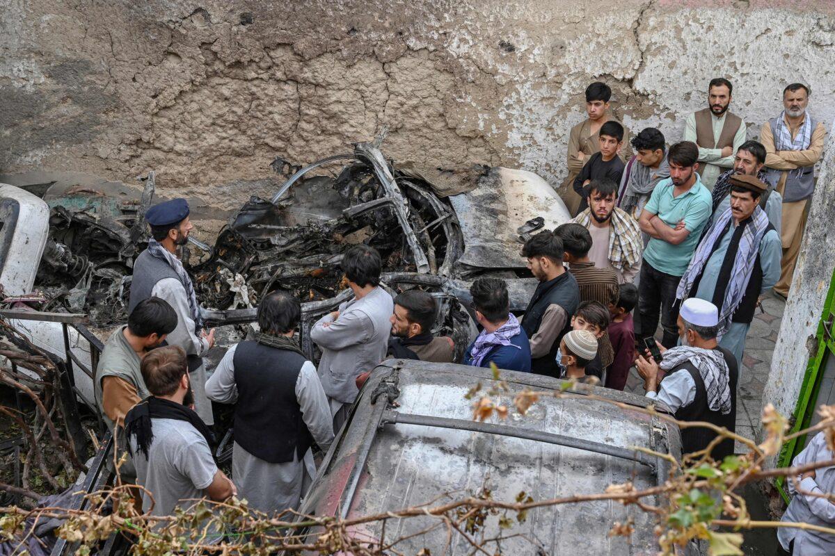 Afghan residents and family members of the victims gather next to a damaged vehicle inside a house, day after a U.S. drone airstrike in Kabul, Afghanistan, on Aug. 30, 2021. (Wakil Kohsar/AFP via Getty Images)