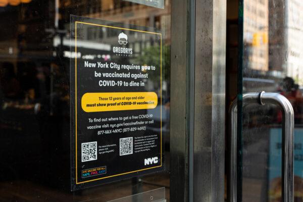 Vaccine proof requirement note displays at a restaurant storefront in New York on September 7, 2021. (Chung I Ho/The Epoch Times)