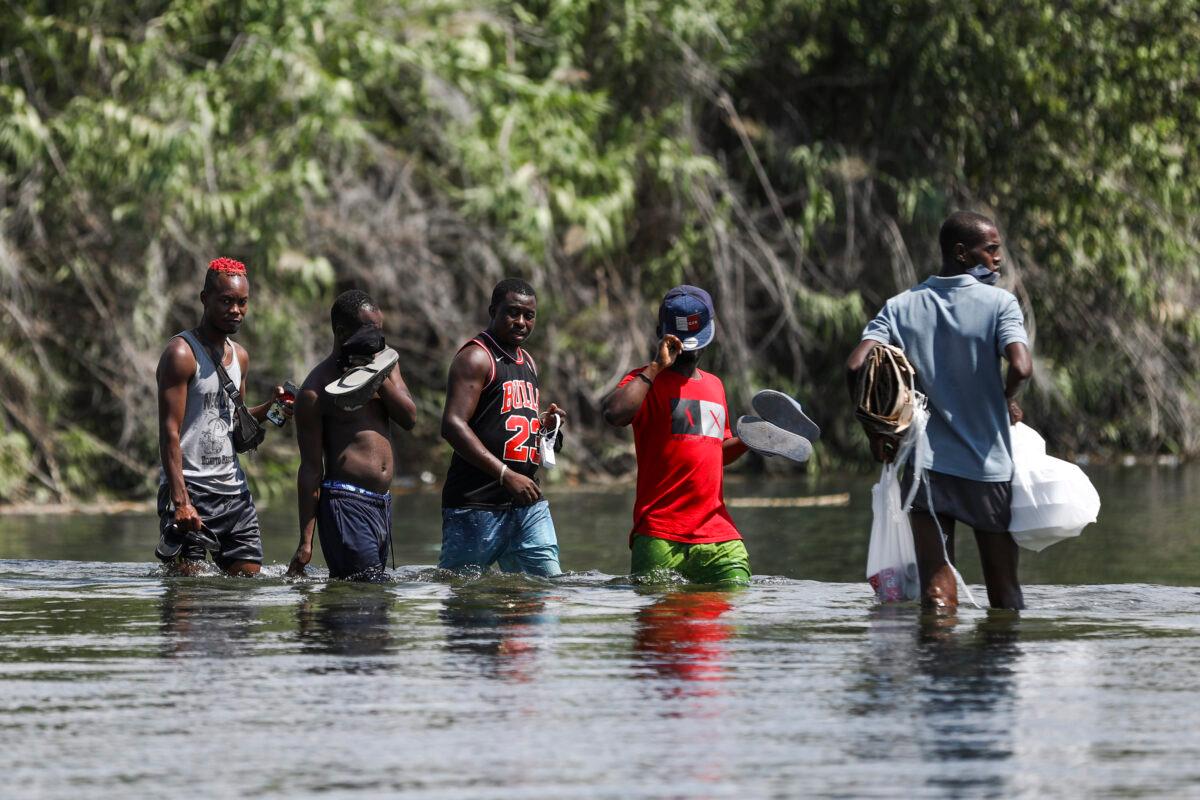Illegal immigrants bring supplies from Acuna, Mexico, into the United States across the Rio Grande, the international boundary with Mexico, in Del Rio, Texas, on Sept. 18, 2021. (Charlotte Cuthbertson/The Epoch Times)