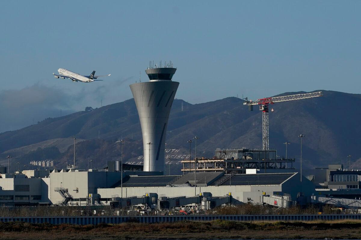 A plane takes off behind the air traffic control tower at San Francisco International Airport in San Francisco on Nov. 24, 2020. (Jeff Chiu/AP Photo)