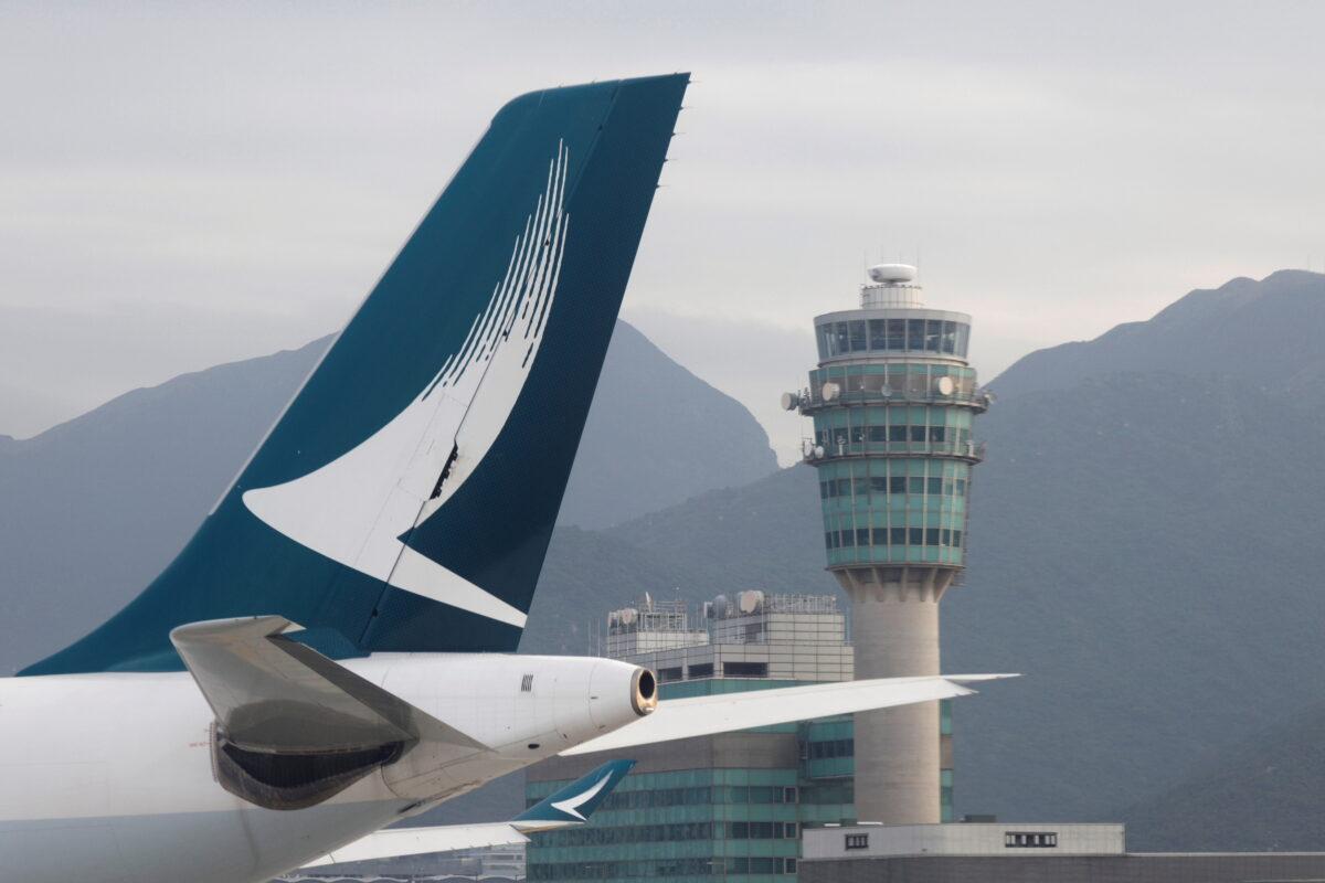 A Cathay Pacific jet is seen in front of an air traffic control tower at the Hong Kong International Airport on Oct. 24, 2020. (Tyrone Siu/Reuters)