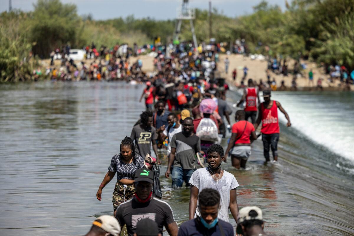 Illegal migrants cross the Rio Grande River near a temporary migrant camp under the international bridge, in Del Rio, Texas, on Sept. 18, 2021. (Jordan Vonderhaar/Getty Images)