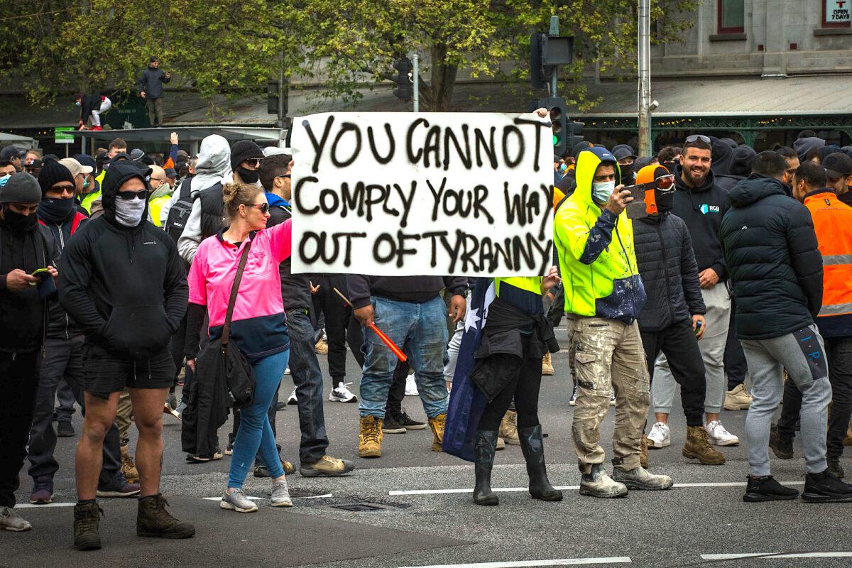 Protesters hold a sign that reads ‘You cannot comply your way out of tyranny’ during demonstrations against mandatory COVID-19 vaccines and restrictions in Melbourne, Australia, on Sept. 21, 2021. (Darrian Traynor/Getty Images)