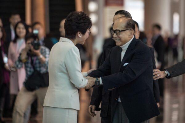 The then-Hong Kong chief executive candidate Carrie Lam (L) shakes hands with tycoon Li Ka-shing before he votes during the Hong Kong chief executive election on March 26, 2017. (Dale De La Rey/AFP via Getty Images)