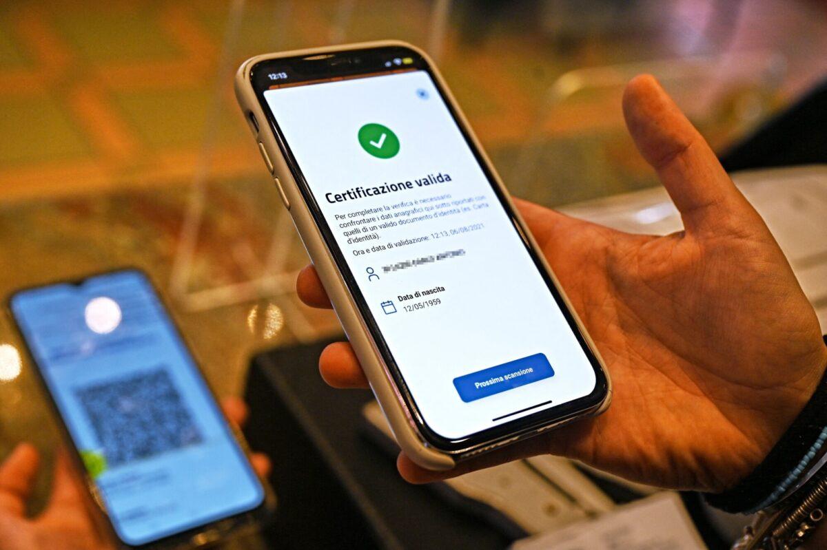  A bar owner uses the VerifyC19 mobile phone application to scan a Green Pass in central Rome, on Aug. 6, 2021. (Andreas Solaro/AFP via Getty Images)