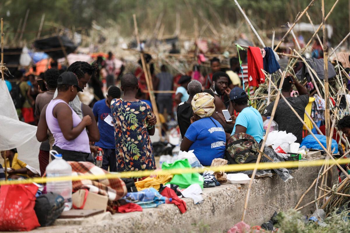 Thousands of illegal immigrants, mostly Haitians, live in a primitive, makeshift camp under the international bridge that spans the Rio Grande between the U.S. and Mexico while waiting to be detained and processed by Border Patrol, in Del Rio, Texas, on Sept. 21, 2021. (Charlotte Cuthbertson/The Epoch Times)
