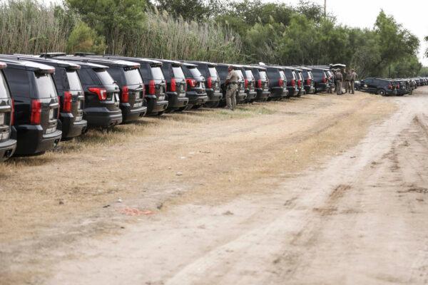 Texas State Trooper vehicles are lined up along the border as thousands of illegal immigrants, mostly Haitians, live in a primitive, makeshift camp under the international bridge that spans the Rio Grande between the U.S. and Mexico while waiting to be detained and processed by Border Patrol, in Del Rio, Texas, on Sept. 21, 2021. (Charlotte Cuthbertson/The Epoch Times)