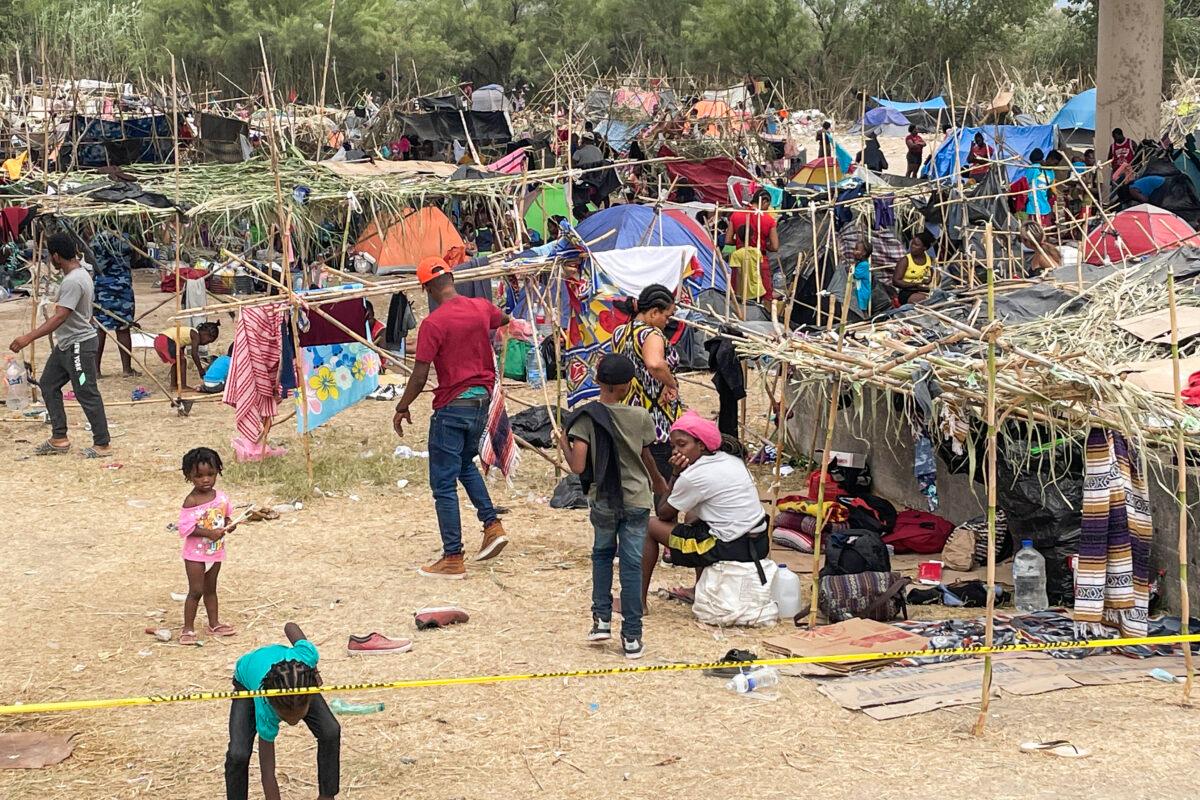 Thousands of illegal immigrants, mostly Haitians, live in a primitive, makeshift camp under the international bridge that spans the Rio Grande between the United States and Mexico while waiting to be detained and processed by Border Patrol, in Del Rio, Texas, on Sept. 21, 2021. (Charlotte Cuthbertson/The Epoch Times)