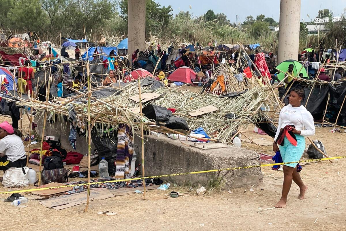 Thousands of illegal immigrants, mostly Haitians, live in a primitive, makeshift camp under the international bridge that spans the Rio Grande between the United States and Mexico while waiting to be detained and processed by Border Patrol in Del Rio, Texas, on Sept. 21, 2021. (Charlotte Cuthbertson/The Epoch Times)