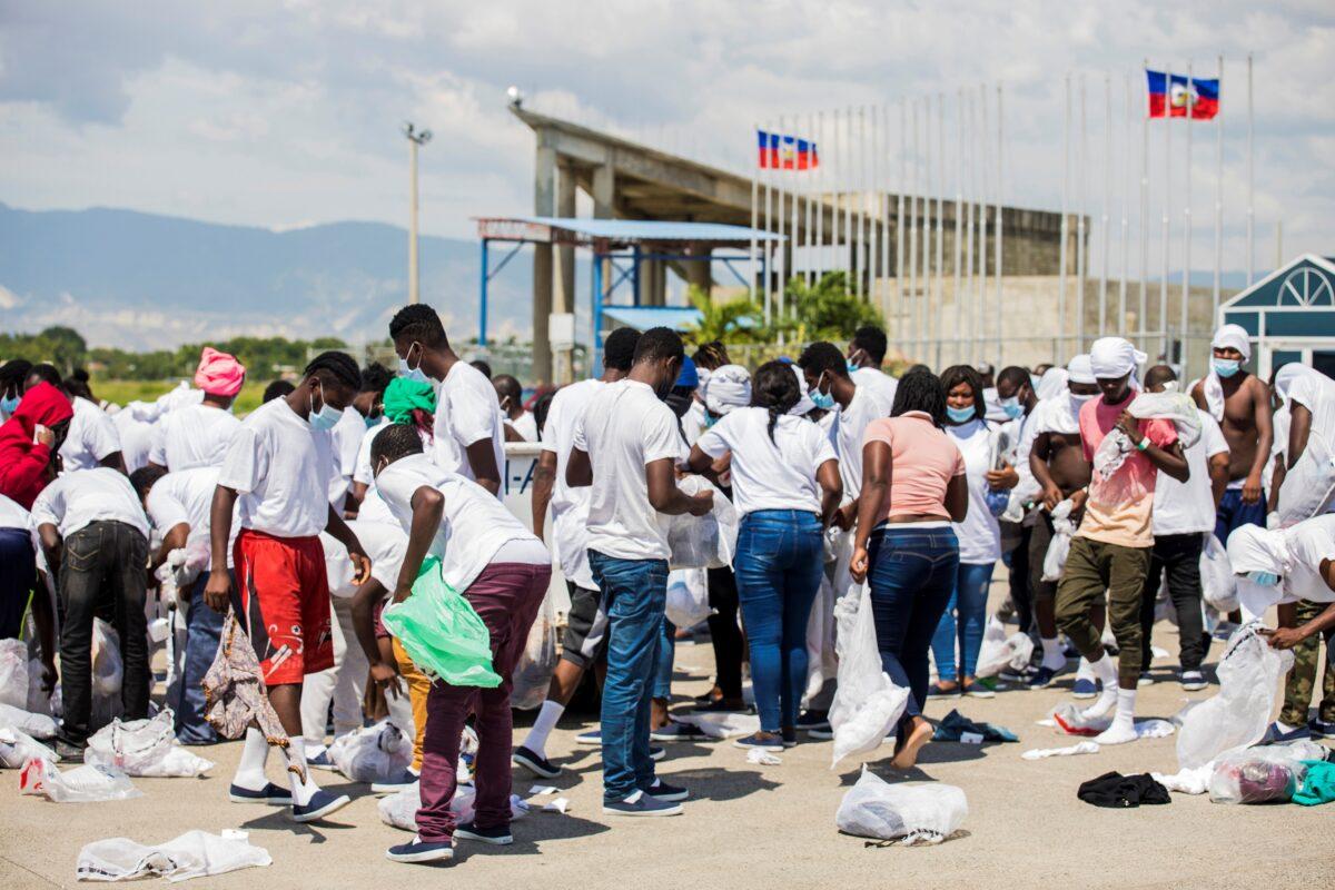 Haitian nationals collect their belongings after U.S. authorities flew them out of a Texas border city after crossing the Rio Grande from Mexico, at Toussaint Louverture International Airport in Port-au-Prince, Haiti, on Sept. 21, 2021. (Ralph Tedy Erol/Reuters)