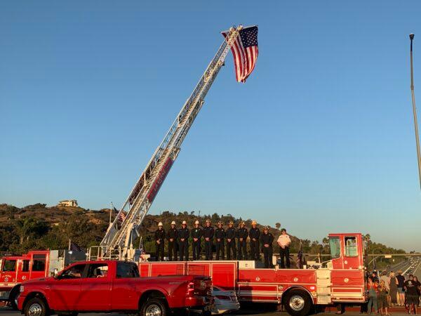 La Verne Firefighters lined up on the overpass paying tribute to Marine Lance Cpl. Dylan R. Merola, in La Verne, Calif., on Sept. 21, 2021. (Linda Jiang/The Epoch Times)
