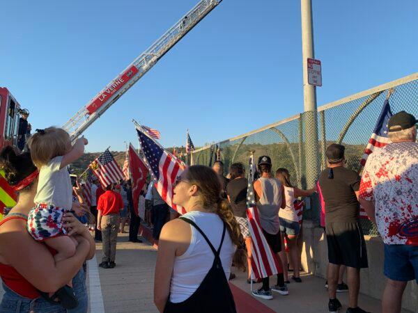 Crowds of people showing their support by lining the procession’s route and waving American flags, in La Verne, Calif., on Sept. 21, 2021. (Linda Jiang/The Epoch Times)
