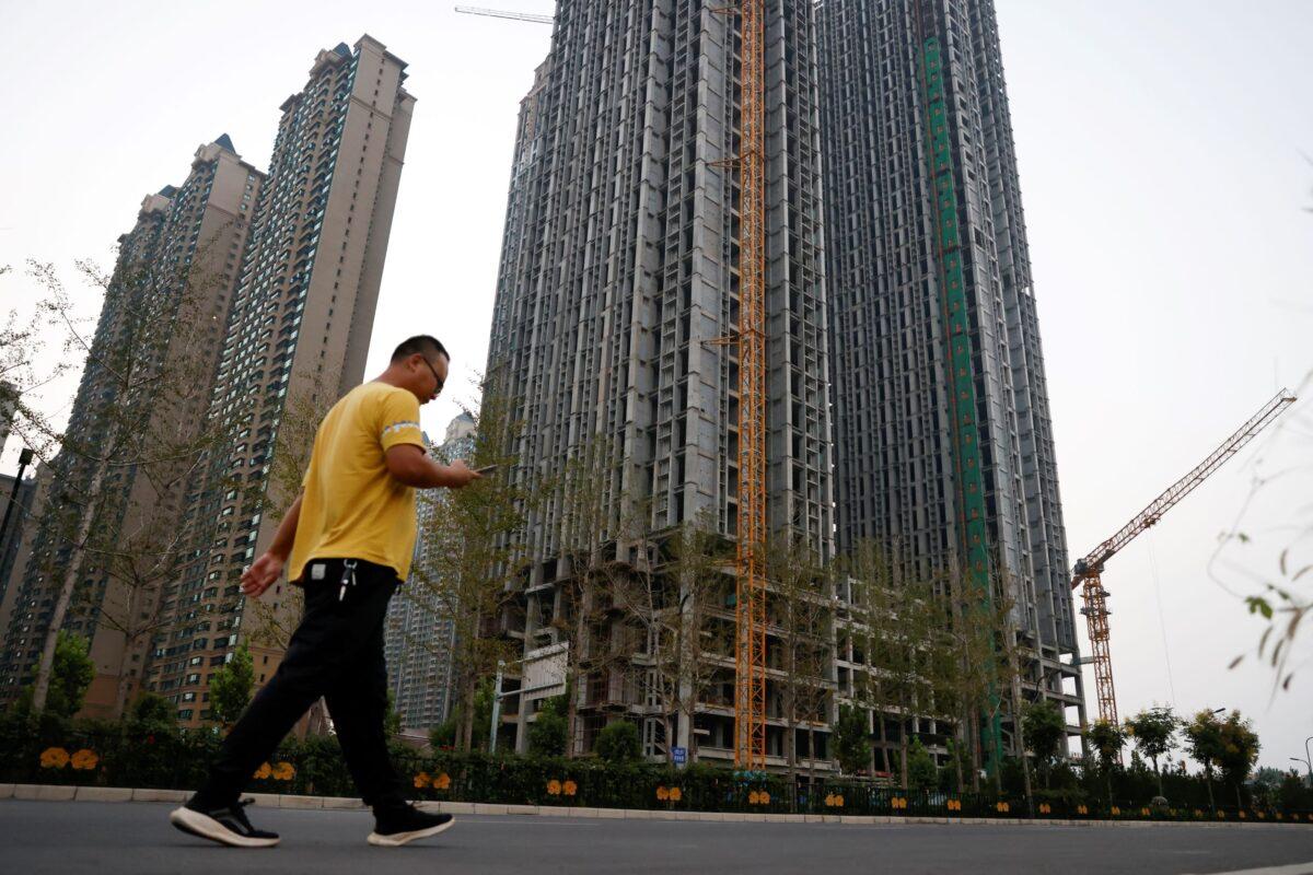 A man walks in front of unfinished residential buildings at the Evergrande Oasis, a housing complex developed by Evergrande Group, in Luoyang, China on Sept. 15, 2021. (Carlos Garcia Rawlins/Reuters)