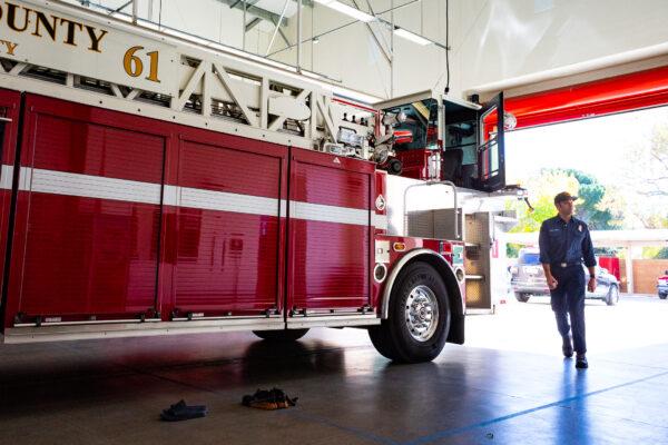 A firefighter walks around a fire engine at Orange County Fire Authority Engine Number 61 in Buena Park, Calif., on Jan. 15, 2021. (John Fredricks/The Epoch Times)