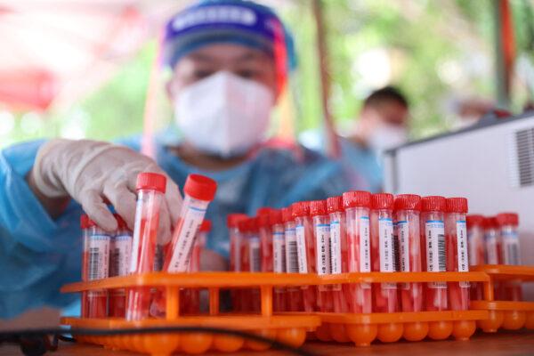 A medical worker collects samples to be tested for the Covid-19 coronavirus in Xiamen, in China's eastern Fujian province on Sept. 18, 2021. (STR/AFP via Getty Images)