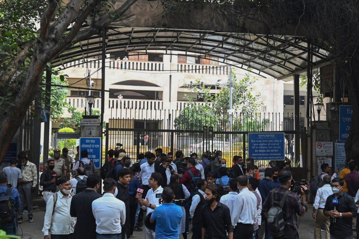 Members of the media gather outside an entrance gate to the Rohini district courtroom in New Delhi, India, on Sept. 24, 2021, after a notorious Indian gangster was killed by gunmen dressed as lawyers in a bloody shootout in a courtroom where three people died. (Money Sharma/AFP via Getty Images)
