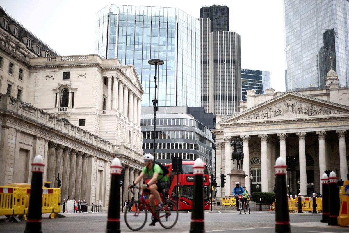 The Bank of England can be seen as people cycle through the City of London financial district, in London, on June 11, 2021. (Henry Nicholls/Reuters)