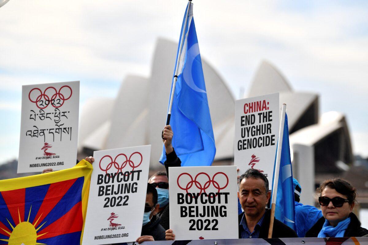 Protesters hold up placards and banners as they attend a demonstration in Sydney to call on the Australian government to boycott the 2022 Beijing Winter Olympics over China's human rights record on June 23, 2021. (Saeed Khan/AFP via Getty Images)