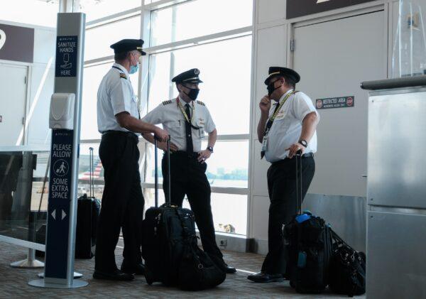 Pilots talk after exiting a Delta Airlines flight at the Ronald Reagan National Airport, in Arlington, Va., on July 22, 2020. (Michael A. McCoy/Getty Images)