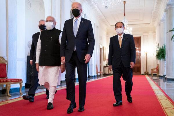 President Joe Biden walks to the Quad summit with, from left, Australian Prime Minister Scott Morrison, Indian Prime Minister Narendra Modi, and Japanese Prime Minister Yoshihide Suga, in the East Room of the White House, in Washington, on Sept. 24, 2021. (AP Photo/Evan Vucci)
