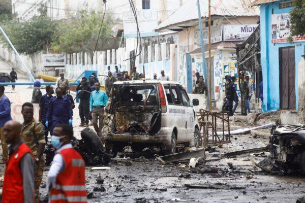 Somalian security officers gather at the scene of a suicide car bomb at a street junction near the president's residence, in Mogadishu, Somalia, on Sept. 25, 2021. (Feisal Omar/Reuters)