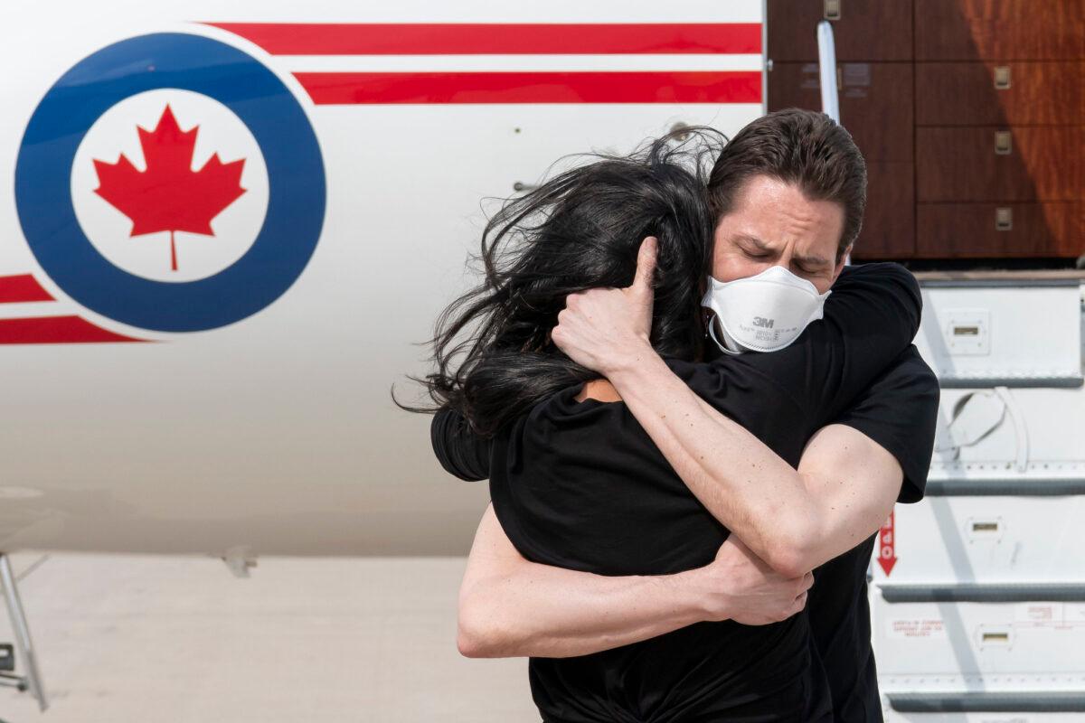 Former diplomat Michael Kovrig embraces his wife Vina Nadjibulla upon his arrival at Toronto Pearson International Airport on Sept. 25, 2021. (DND-MDN Canada/Cpl. Justin Dreimanis)