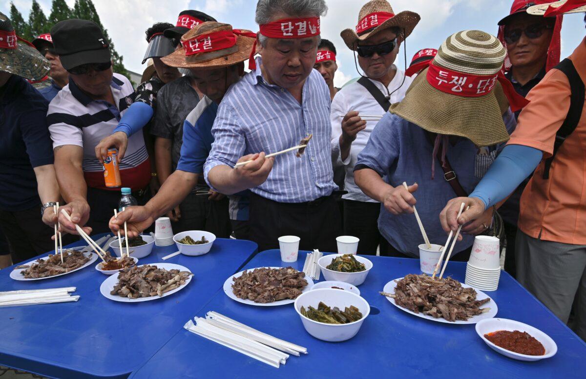 South Korean dog farmers eat dog meat during a counter-rally against animal rights activists, in Seoul, South Korea, on July 12, 2019. (Jung Yeon-je/AFP/Getty Images)