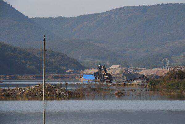 This photo taken Nov. 3, 2014, shows a factory and power poles partly submerged below the Danjiangkou Reservoir in China's central Henan Province. (Greg Baker/AFP via Getty Images)