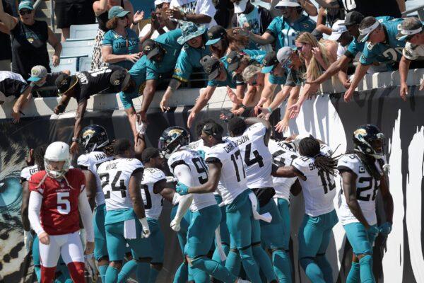 Fans celebrate with Jacksonville Jaguars players after wide receiver Jamal Agnew ran back an Arizona Cardinals missed field goal for a 109-yard touchdown return during the first half of an NFL football game, in Jacksonville, Fla., on Sept. 26, 2021. (Phelan M. Ebenhack/AP Photo)