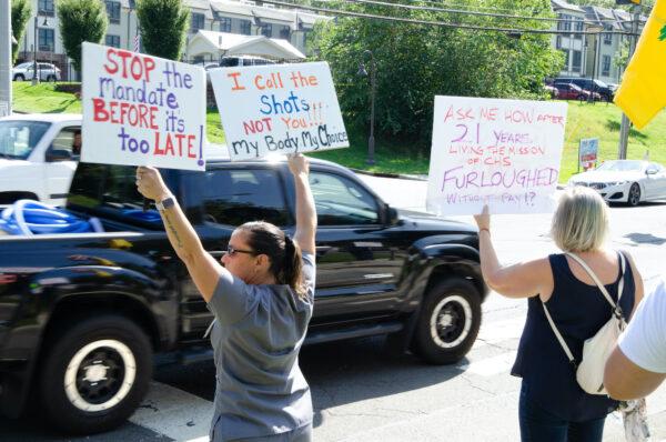 Protesters against the COVID-19 vaccine mandate hold signs outside the St. Catherine of Siena Medical Center in Smithtown, Long Island on Sept. 27. (Dave Paone/The Epoch Times)