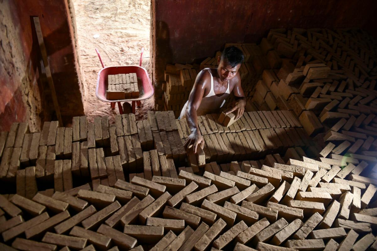 A man arranges dry bricks before firing in the furnace at a brick factory on the outskirts of Kajhu, Aceh Province, Indonesia, on Nov. 18, 2020. (Chaideer Mahyuddin/AFP)