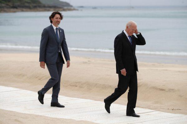 Canadian Prime Minister Justin Trudeau (L) and U.S. President Joe Biden walk along the boardwalk during the G7 summit in Carbis Bay, Cornwall, southwest England, on June 11, 2021. (Phil Noble/POOL/AFP via Getty Images)