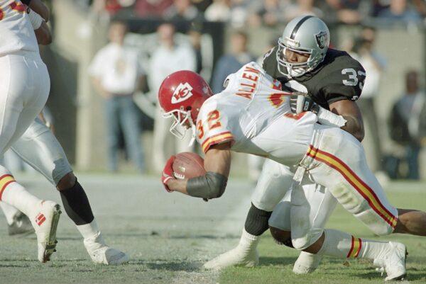Kansas City Chiefs' running back Marcus Allen crosses the goal line for a third quarter touchdown as Los Angeles Raiders' Eddie Anderson tries to stop him in Los Angeles, Calif., on Nov. 14, 1993. (Eric Draper/AP Photo)