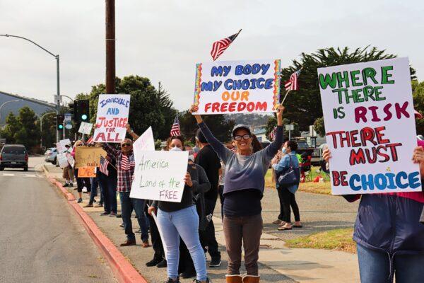 People hold signs calling for freedom of choice during a rally protesting vaccine mandates in Monterey, Calif., on Sept. 26, 2021. (Cynthia Cai/The Epoch Times)