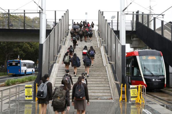 Students walk up the stairs of the overpass at the Sydney Light Rail Moore Park stop on their way to school in Sydney, Australia, on May 25, 2020. (Mark Kolbe/Getty Images)