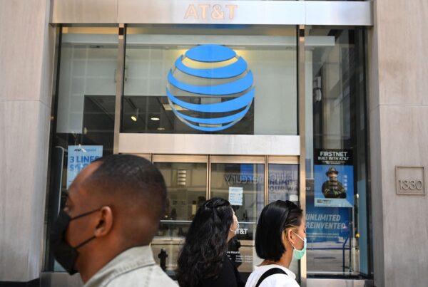People walk past an AT&T store in New York, on May 17, 2021. (Timothy A. Clary/AFP via Getty Images)