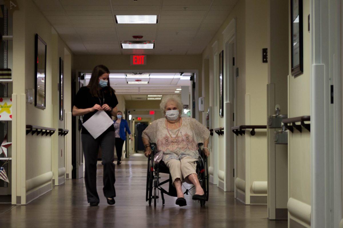 A caregiver walks with a nursing home resident at a Quality Life Services facility in western Pennsylvania. (Courtesy of the Pennsylvania Health Care Association)
