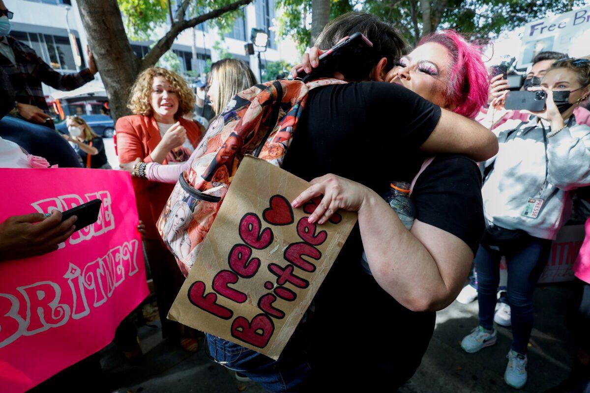 Supporters of pop star Britney Spears hug as they celebrate after a judge suspended the father of Britney Spears from his 13-years-long role as the controller of the singer's business affairs at Stanley Mosk Courthouse in Los Angeles, California, on Sept. 29, 2021. (Mario Anzuoni/Reuters)