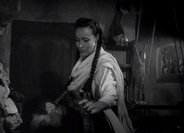 The local woman (Dolores del Rio) comforts the exhausted priest (Henry Fonda). (RKO Radio Pictures)