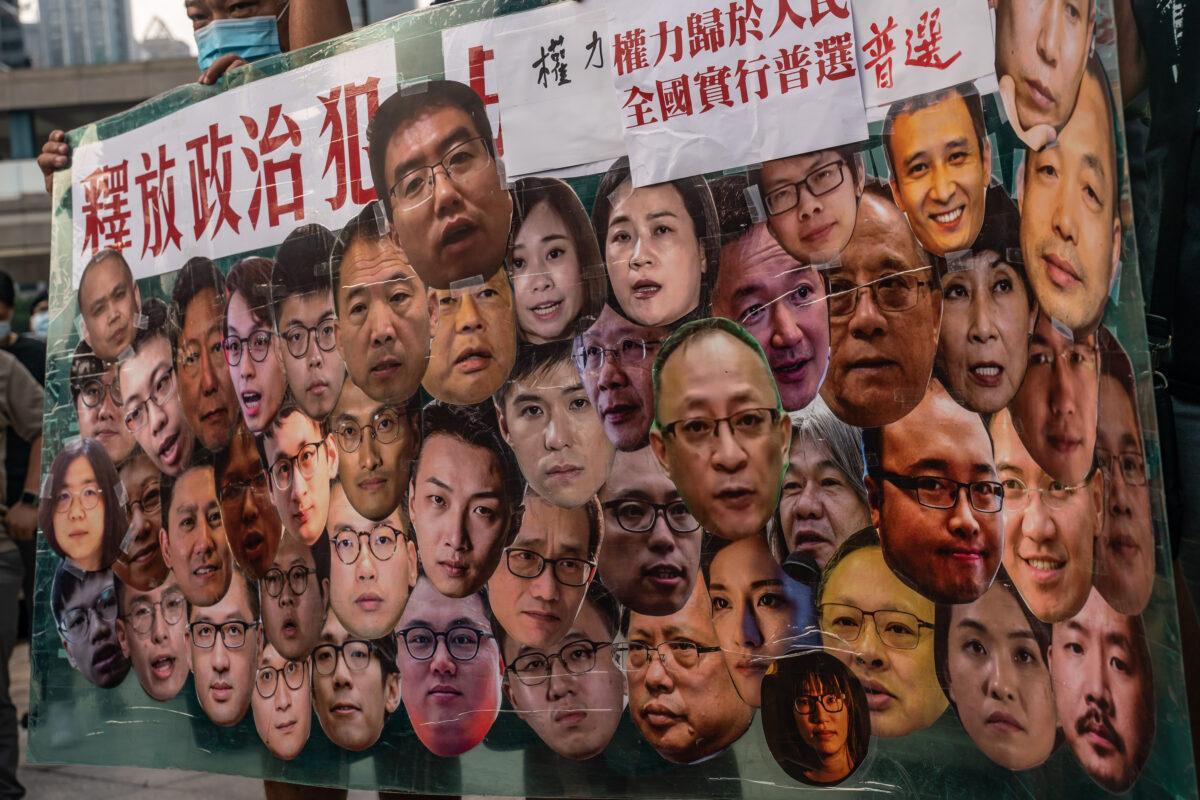 Pro-democracy activists hold a banner with political prisoners photos during a protest in the Wan Chai district in Hong Kong on Oct. 1, 2021 (Anthony Kwan/Getty Images)